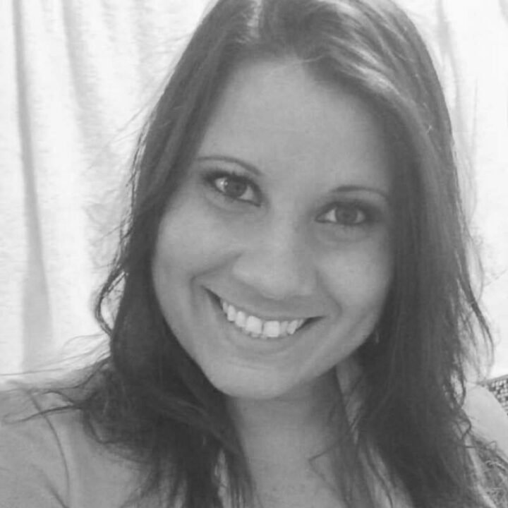 Juliana Matola, sócia e gerente geral, sorrindo em uma foto em preto e branco, destacando sua liderança na Agência Mais Resultado.