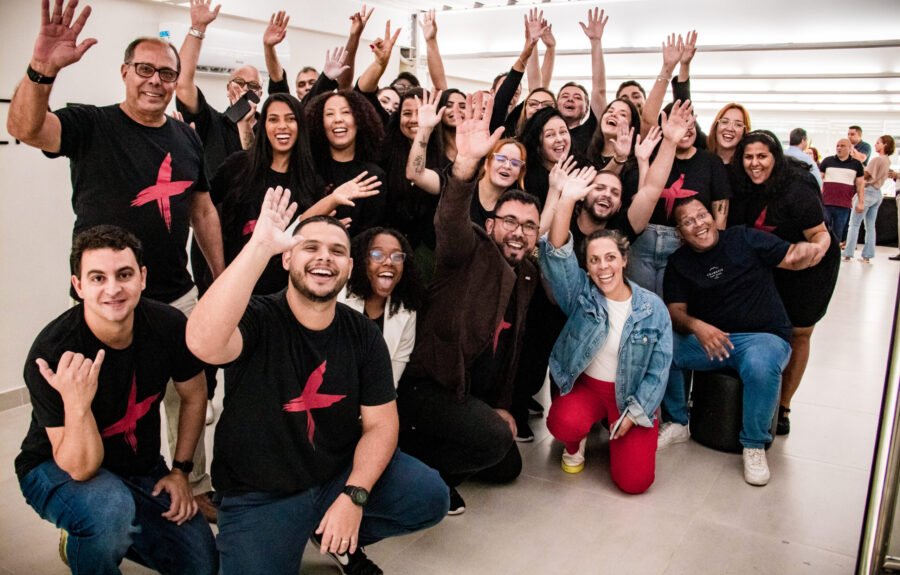 Equipe da Agência Mais Resultado celebrando 10 anos de atuação, sorrindo e acenando em um momento de confraternização.