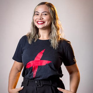 Mariana Gomes, gerente geral, sorrindo e usando uma camiseta preta com estampa vermelha em sessão de fotos para a página da diretoria.